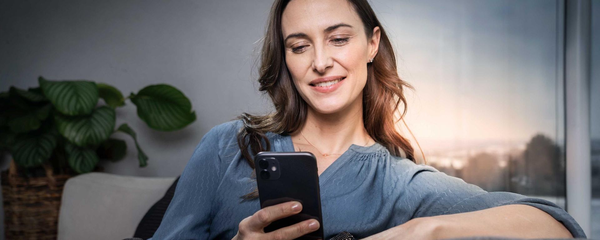 Frau mit dem Smartphone auf der Couch