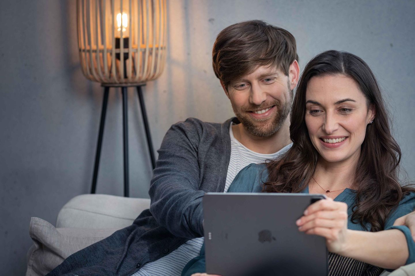 Paar sitzt mit Tablet auf der Couch