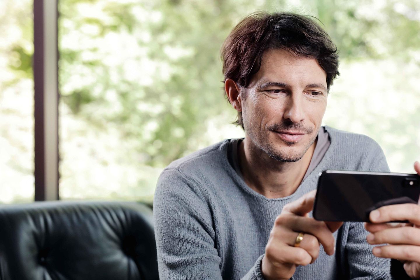 Mann schaut auf sein Smartphone Mann schaut auf sein Smartphone