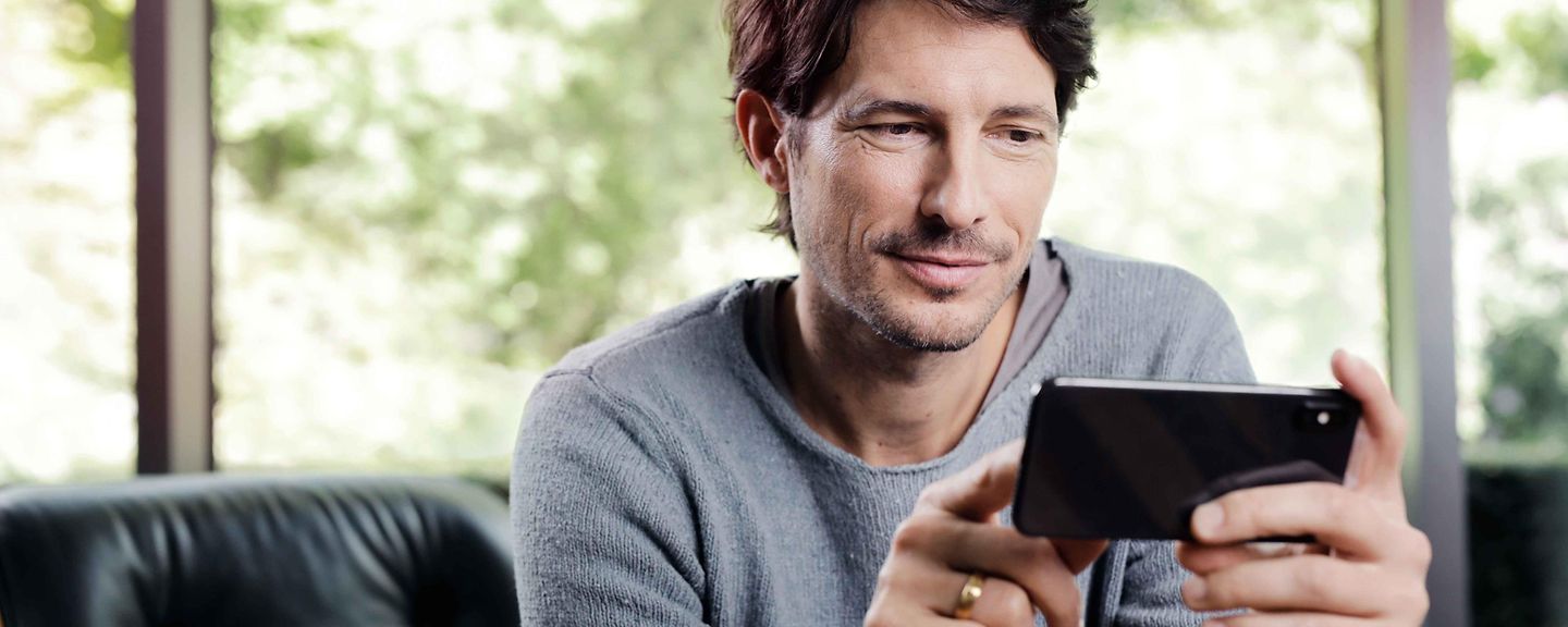 Mann schaut auf sein Smartphone Mann schaut auf sein Smartphone