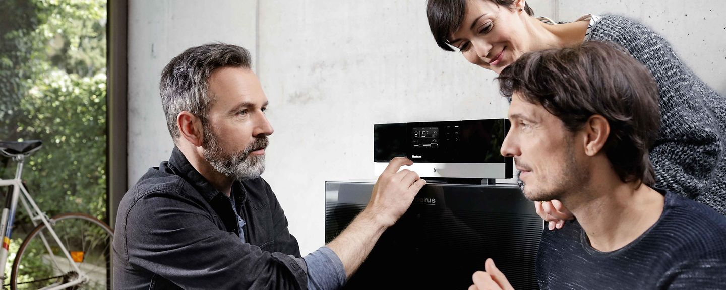 Installateur schaut sich mit Ehepaar Gasheizung an Installateur schaut sich mit Ehepaar Gasheizung an